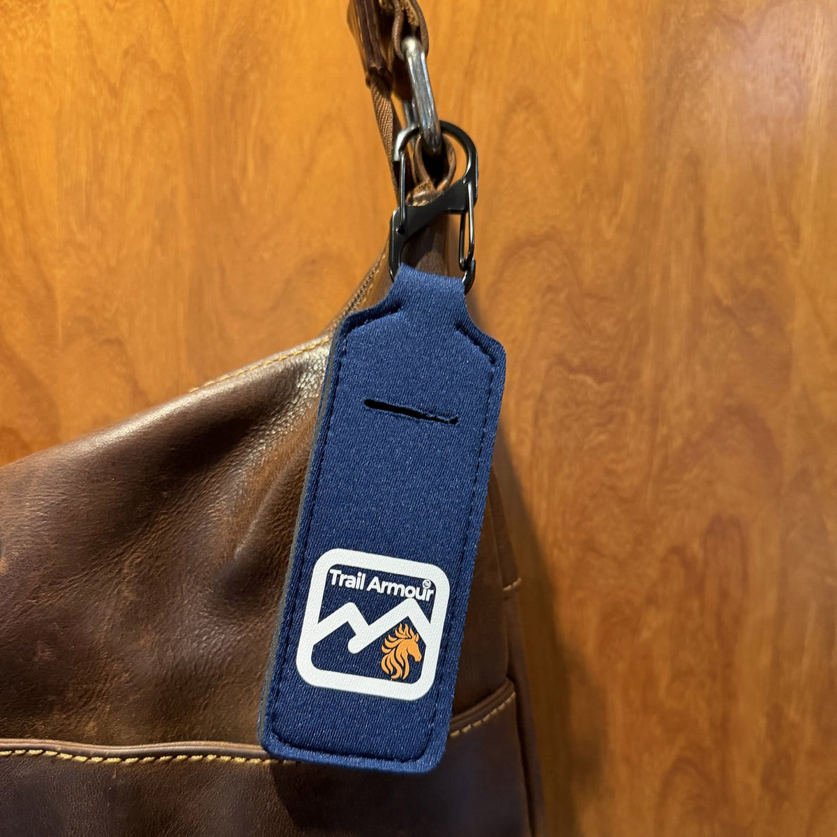 Navy neoprene Trail Armour lip balm holder showing the metal S clip and the slot in the front